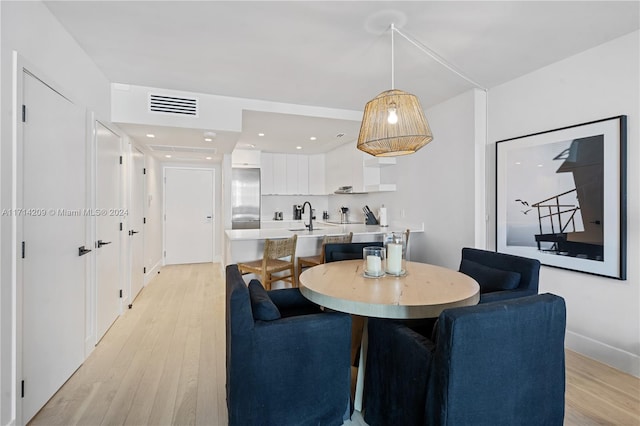 dining room featuring sink and light hardwood / wood-style flooring