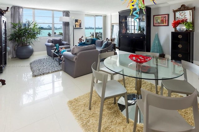 dining room with light tile patterned floors, a water view, and crown molding