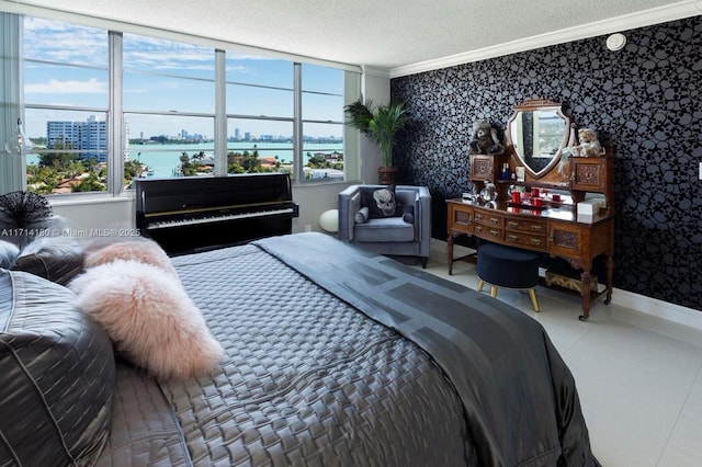 bedroom featuring ornamental molding, a water view, a textured ceiling, and wallpapered walls