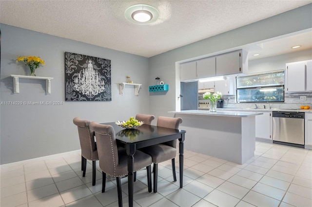 tiled dining area featuring sink and a textured ceiling