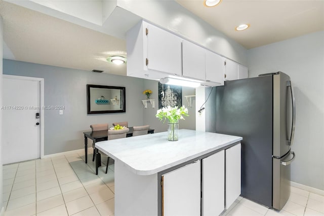 kitchen featuring stainless steel fridge, light tile patterned flooring, white cabinetry, and kitchen peninsula