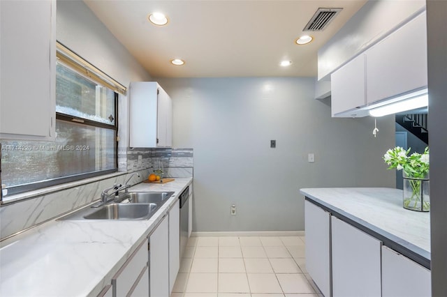 kitchen featuring white cabinetry, plenty of natural light, dishwasher, and sink