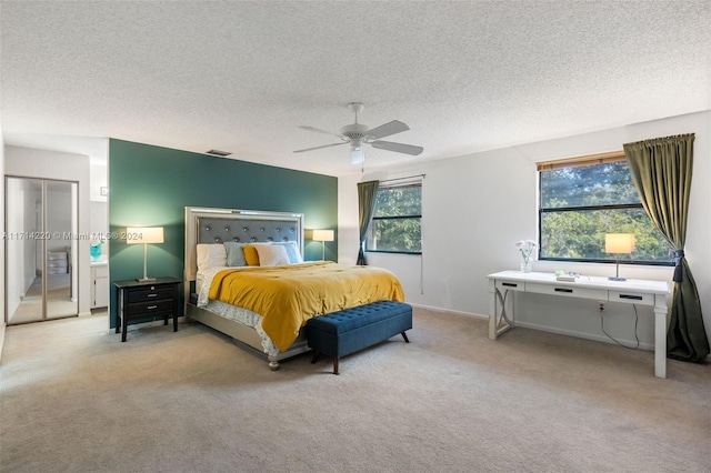 carpeted bedroom with a textured ceiling and ceiling fan