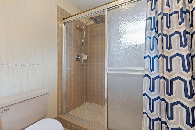 bathroom with a shower with shower curtain and toilet