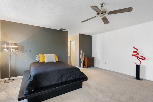 bedroom with light carpet, a textured ceiling, and ceiling fan