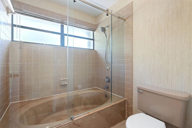 bathroom with shower / bath combination with glass door and toilet