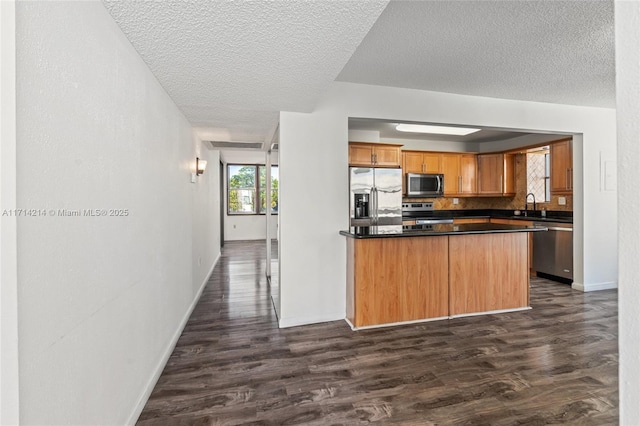 kitchen with dark hardwood / wood-style floors, stainless steel appliances, tasteful backsplash, and sink