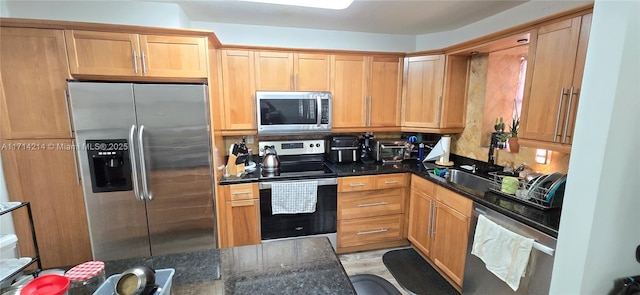 kitchen featuring dark stone countertops and appliances with stainless steel finishes