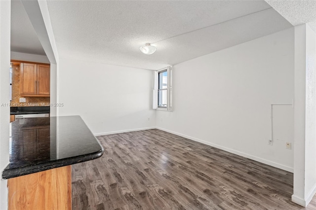 interior space featuring a textured ceiling and dark wood-type flooring