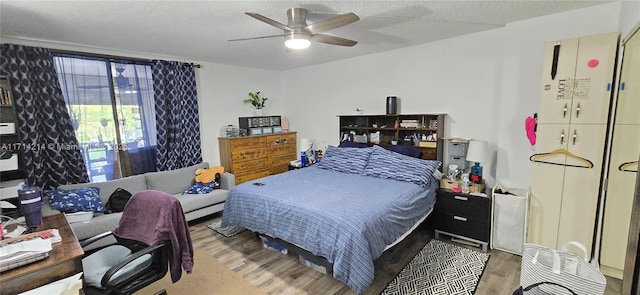 bedroom featuring hardwood / wood-style floors, ceiling fan, and a textured ceiling