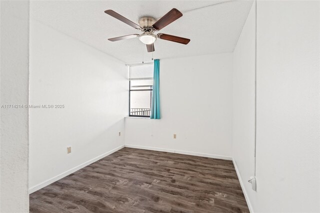 spare room with a textured ceiling, ceiling fan, and dark wood-type flooring