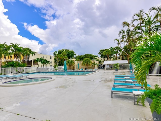 view of swimming pool with a community hot tub and a patio area