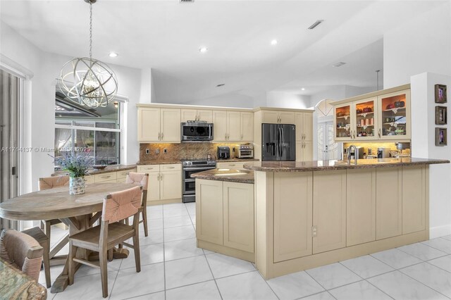 821 E Cypress Pointe Dr E, Pembroke Pines, FL 33027 - kitchen with appliances with stainless steel finishes, cream cabinets, backsplash, dark stone countertops, and a peninsula