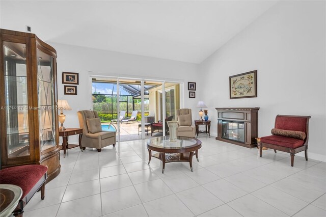 821 E Cypress Pointe Dr E, Pembroke Pines, FL 33027 - living area with a sunroom, light tile patterned flooring, a glass covered fireplace, and high vaulted ceiling