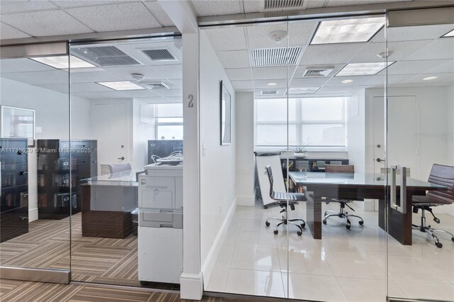 tiled home office featuring a paneled ceiling