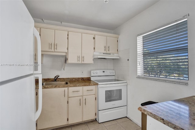 kitchen with white appliances, light tile patterned floors, sink, backsplash, and cream cabinetry