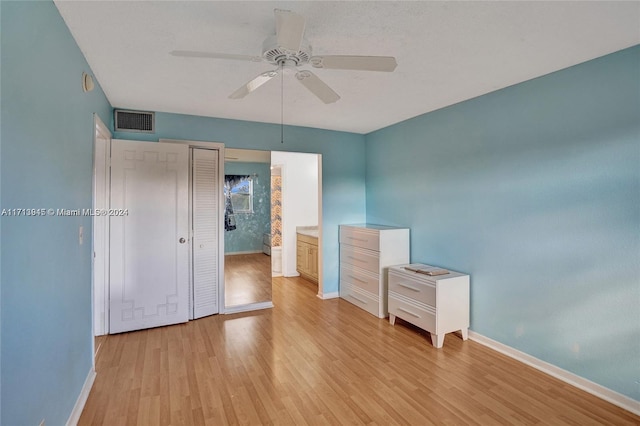 unfurnished bedroom with ceiling fan, light hardwood / wood-style floors, a closet, and ensuite bathroom