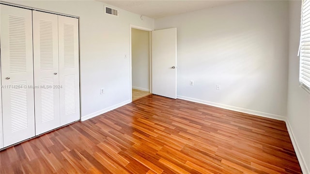 unfurnished bedroom featuring a closet and hardwood / wood-style flooring