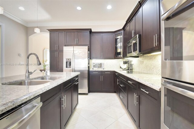 kitchen featuring sink, stainless steel appliances, crown molding, decorative light fixtures, and dark brown cabinets