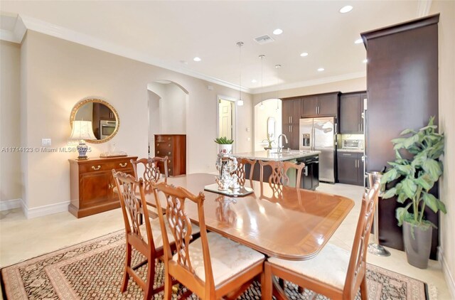 dining area with ornamental molding and sink