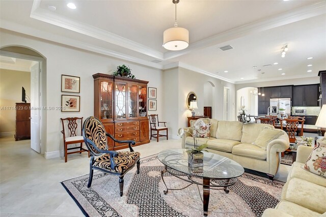 living room with a raised ceiling and crown molding