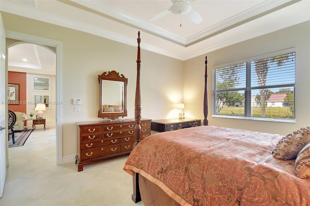 bedroom with a raised ceiling, ceiling fan, and ornamental molding