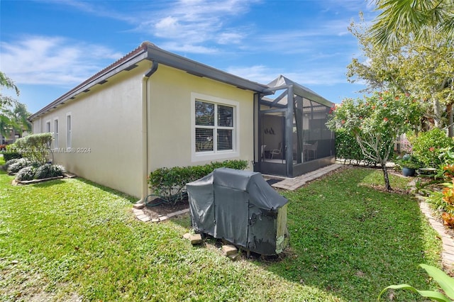 view of side of property with a yard and a lanai