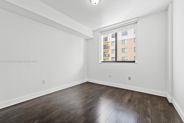 empty room with dark hardwood / wood-style flooring