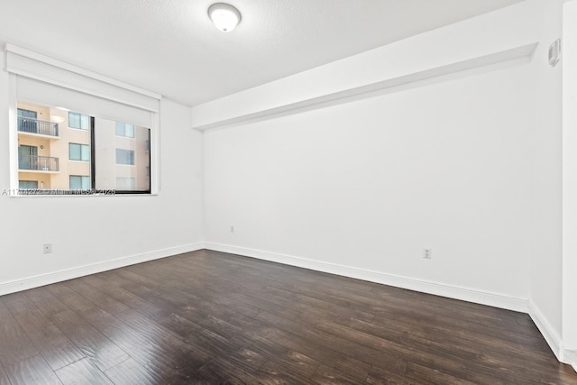 unfurnished room with dark hardwood / wood-style floors and a textured ceiling