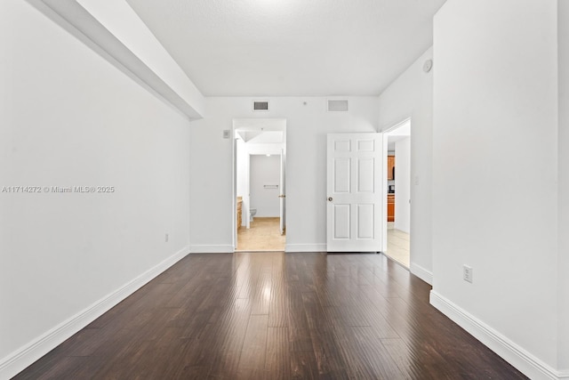 empty room featuring dark wood-type flooring