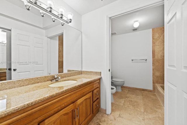 bathroom featuring vanity, toilet, and a bidet