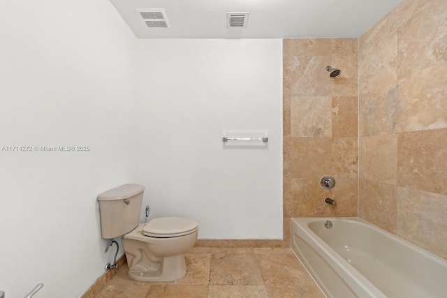 bathroom with toilet and tiled shower / bath