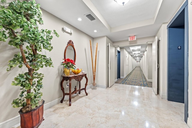 hallway with a tray ceiling