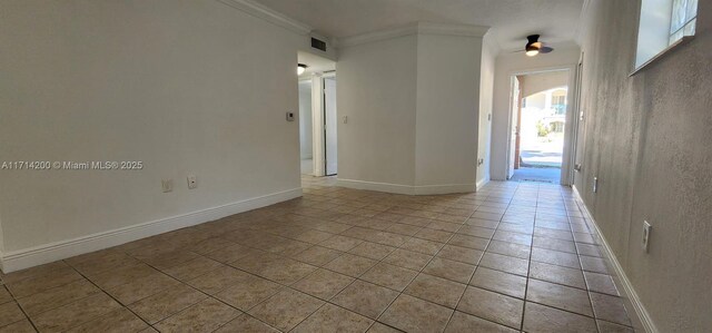 empty room featuring crown molding, light tile patterned floors, and ceiling fan