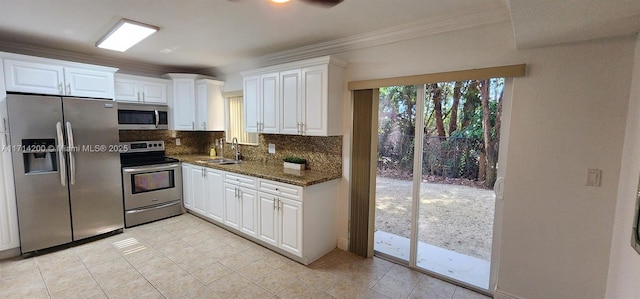 kitchen featuring sink, white cabinetry, stainless steel appliances, tasteful backsplash, and dark stone counters