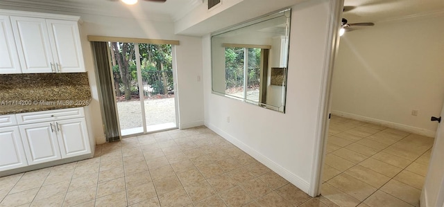 interior space with crown molding, ceiling fan, and light tile patterned floors