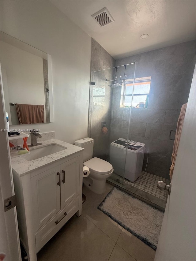 bathroom with tile patterned flooring, vanity, toilet, and a shower with door