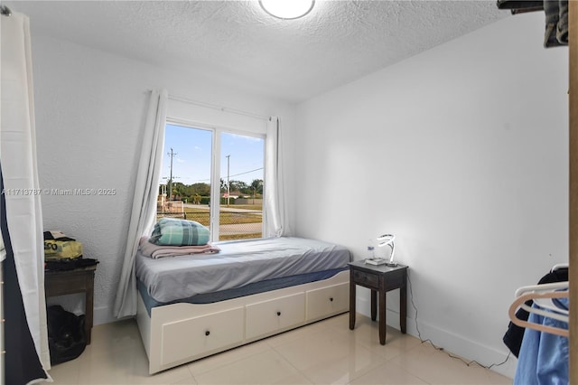 tiled bedroom featuring a textured ceiling