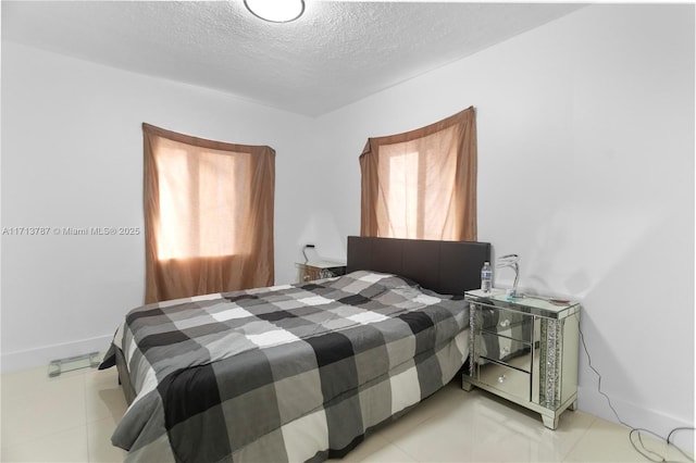 bedroom with a textured ceiling and light tile patterned floors