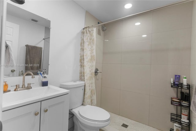 full bathroom featuring toilet, visible vents, tiled shower, and vanity