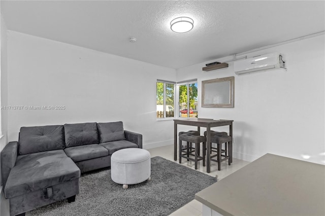 living area featuring a wall unit AC and a textured ceiling