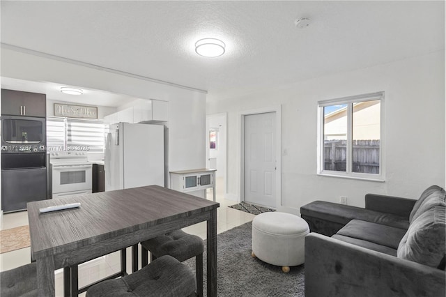 living area featuring a textured ceiling, baseboards, and tile patterned floors