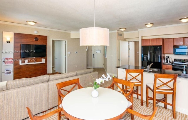 dining space with ornamental molding and sink