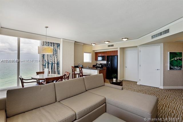 carpeted living room featuring a water view