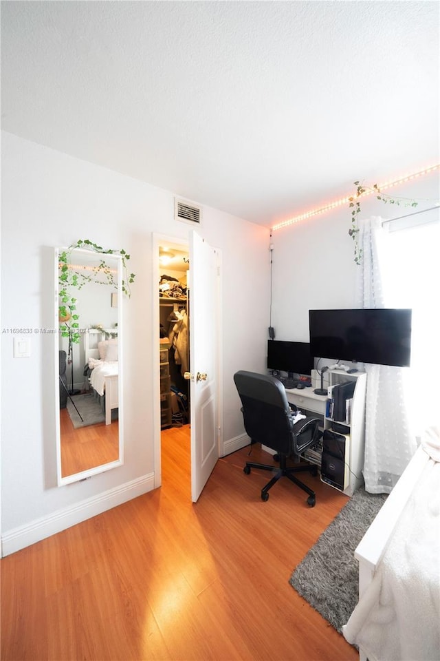 home office with wood-type flooring