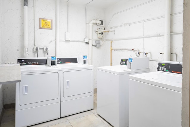 clothes washing area featuring light tile patterned flooring and washing machine and dryer