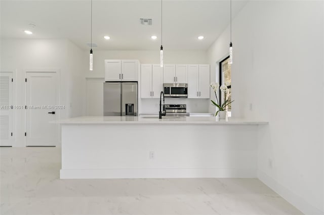 kitchen featuring white cabinets, sink, decorative light fixtures, kitchen peninsula, and stainless steel appliances