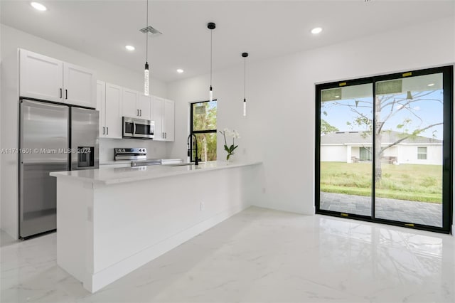 kitchen featuring pendant lighting, sink, light stone counters, white cabinetry, and stainless steel appliances