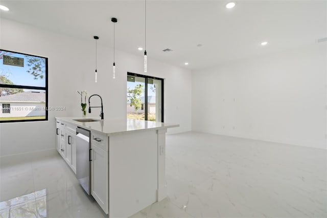 kitchen with sink, dishwasher, white cabinetry, hanging light fixtures, and an island with sink