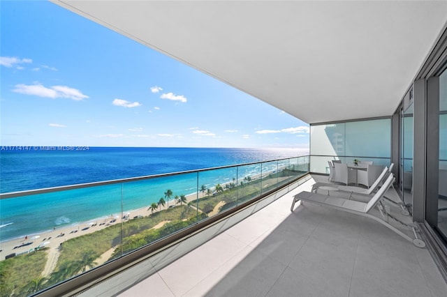 balcony featuring a view of the beach and a water view